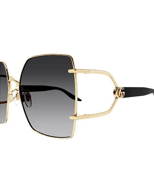 Side view of Rectangular oversized Gucci sunglasses. The temples are black, and the large lenses appear to be a gradient black with GG logo and gold rim. 