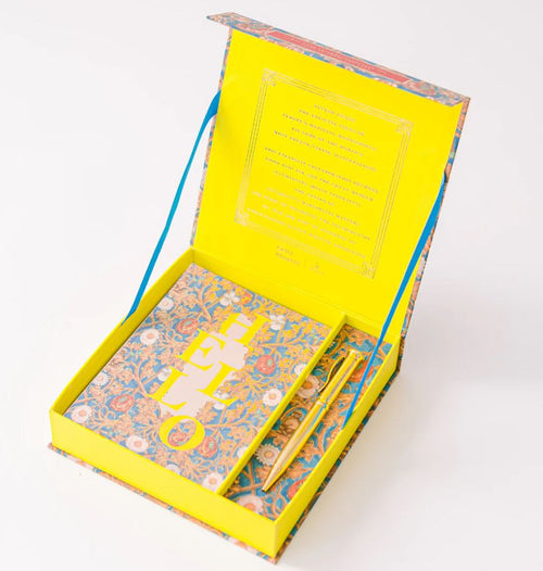 A vibrant stationery set includes a floral-patterned notecards with "HELLO" in bold yellow and a coordinating pen in a bright yellow box with blue accents.