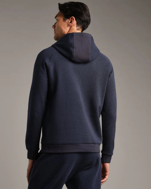 Back view of a navy pullover hoodie with long sleeves, attached hood, ribbed hem and cuffs, soft knit fabric, and matching navy jogger pants.