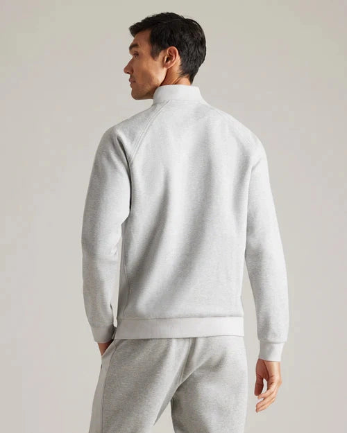 Back view of a light gray quarter-zip pullover with long sleeves, mock neck collar, ribbed cuffs, and matching light gray jogger pants in a studio setting.