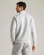 Back view of a light gray quarter-zip pullover with long sleeves, mock neck collar, ribbed cuffs, and matching light gray jogger pants in a studio setting.