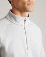 Close-up of a light gray quarter-zip pullover featuring a mock neck collar, quarter-zip closure, raglan seams, and soft knit fabric.