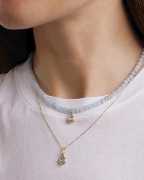 Necklace with teardrop pendant worn by a person on a white background