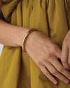 Model's hand wearing bangle, close up shot.