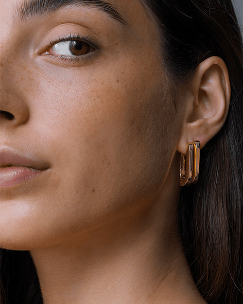 Close up shot of model's side face showing two of the U-Link earrings.