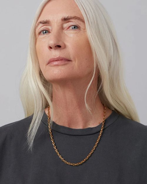 Head shot of a woman wearing the gold coffee bean chain around her neck.