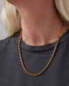 Up close image of a gold chain necklace around a woman's neck