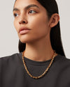 A headshot of a woman wearing Jenny Bird Alber Chain gold necklace