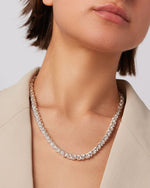 mage of a woman's neck wearing a silver braided necklace