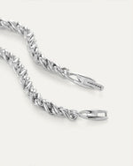 Up-close image of the braided silver necklace clasp opened with the Jenny Bird logo on it.