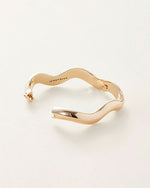 A gold bracelet featuring an elegant wave design, showcasing a smooth and flowing aesthetic.