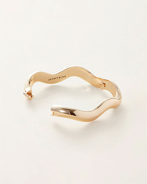 A gold bracelet featuring an elegant wave design, showcasing a smooth and flowing aesthetic.