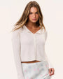 White lightweight button-front cardigan styled with a pastel blue floral skirt, women's casual spring and summer fashion outfit on a neutral studio background.