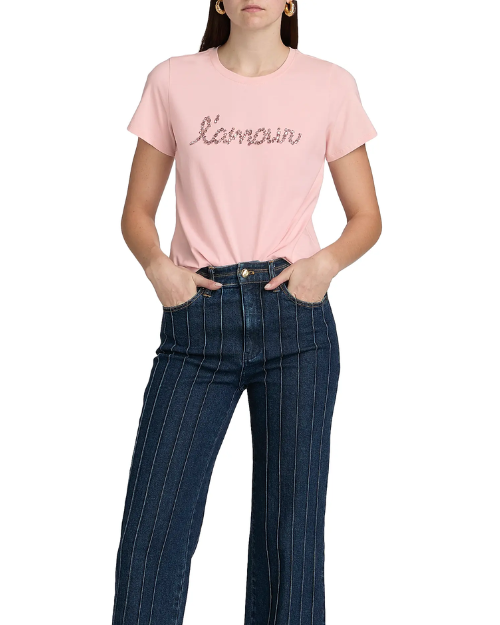 Person wearing a light pink graphic T-shirt with dark pinstriped jeans on a plain background.