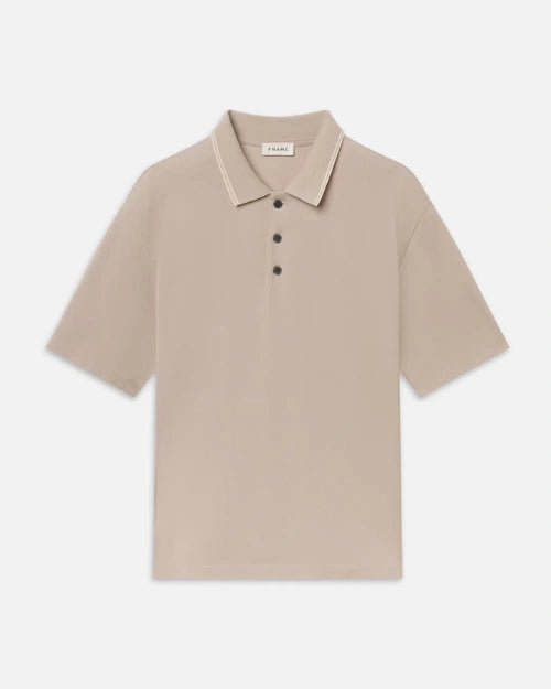 Beige short-sleeve polo shirt featuring a classic collar, contrast tipping detail, and a three-button placket on a light grey background.
