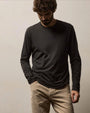 A man wearing a Carbon Elevated Lotus Jersey long sleeve shirt and khaki pants stands confidently.
