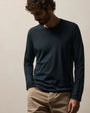 A man wearing a French Navy long sleeve crew shirt and khaki pants stands confidently.