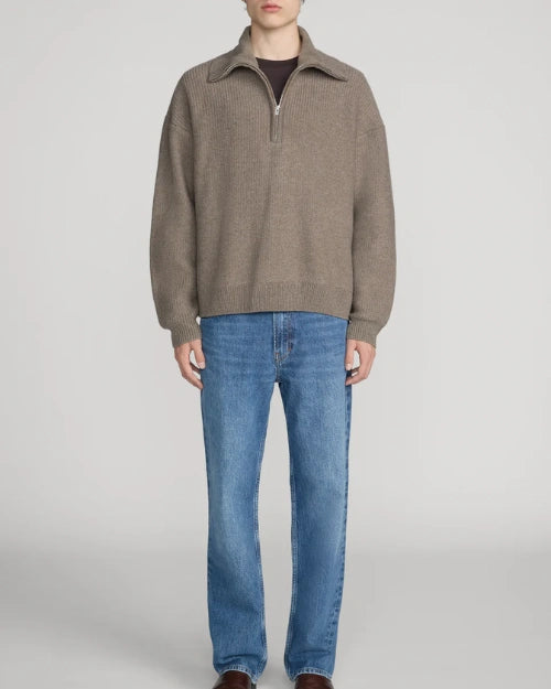 Taupe quarter-zip knit sweater featuring a relaxed fit, ribbed trims, and a wide collar, styled with blue straight-leg jeans on a light grey background.