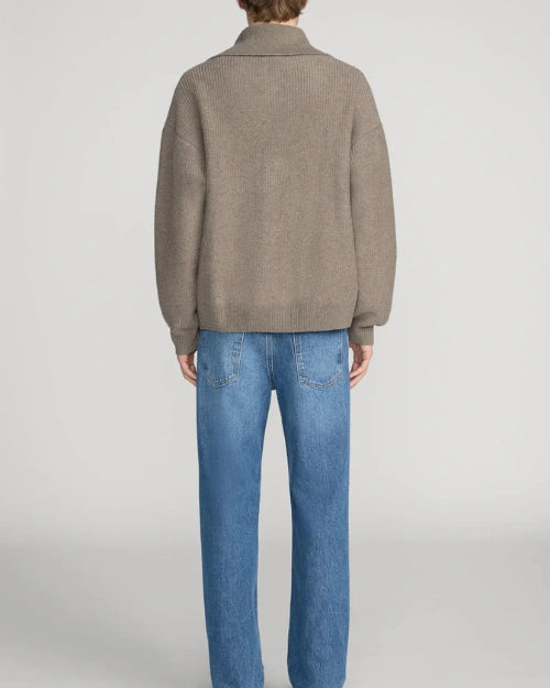 Back view of a taupe quarter-zip knit sweater featuring a relaxed fit, ribbed trims, and a wide collar, styled with blue straight-leg jeans on a light grey background.