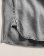 Detailed view of a gray long sleeve shirt bottom and made of 100% linen with a pocket.