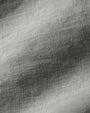 Detailed view of a plain white linen fabric, highlighting its soft texture and breathable nature.