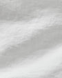 Close-up view showing detail of a white linen long sleeve shirt.