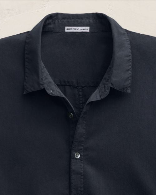 Close-up image of a button-up shirt made of cotton, highlighting the button-down collar design.