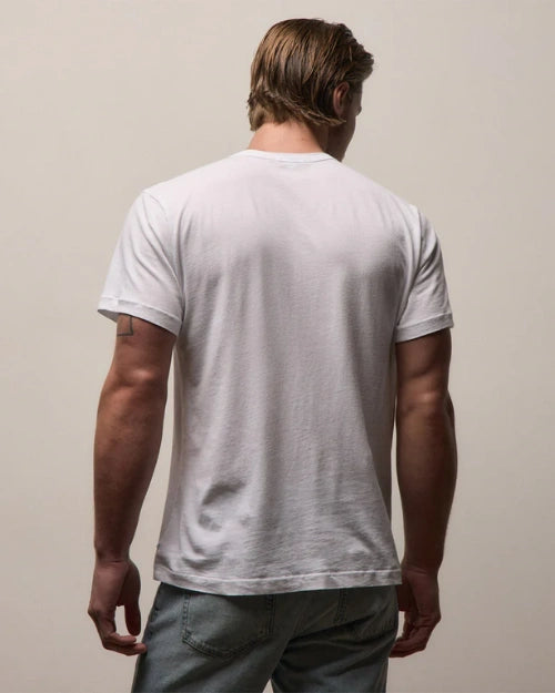 Back view of a white crew neck T-shirt featuring a classic short-sleeve design and relaxed fit, styled with light wash denim jeans on a neutral studio background.