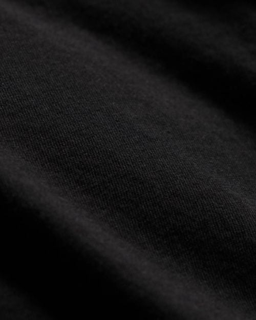 Detailed view of a black long sleeve crew neck cotton shir.