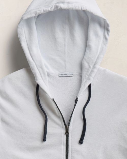A white zip-up hoodie made from lightweight Supima cotton terry, showcasing a vintage French Terry design.
