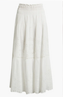 A white midi‑length skirt featuring an elastic smocked waistband and a tiered silhouette. The fabric includes eyelet embroidery with floral cutout patterns across each tier, creating a lightweight and airy look. The hemline is gently scalloped, and the skirt is displayed against a plain white background.