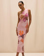 One-shoulder pink midi dress featuring large floral prints in pink, orange, and white tones, shown on a model against a neutral studio background.