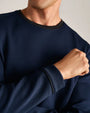 Close-up detail of a navy long-sleeve performance crewneck shirt showcasing textured knit fabric, ribbed collar and cuff construction.