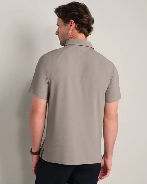 Back view of a light taupe short-sleeve polo shirt featuring a classic collar, textured fabric and relaxed modern fit.