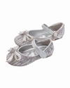 A pair of little girls silver shoes covered in rhinestones and pearls featuring a decorative bow on the toe, elegantly designed for formal occasions.
