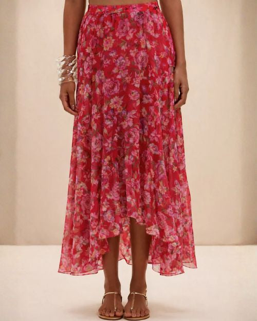 A woman in a pink floral Peony Print Lycra maxi skirt, exuding elegance and charm in her outfit.