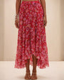 A woman in a pink floral Peony Print Lycra maxi skirt, exuding elegance and charm in her outfit.