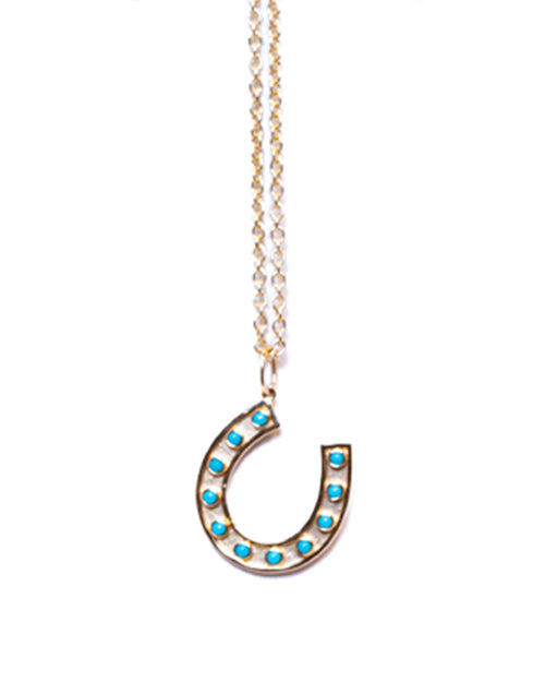 Gold chain with turquoise and gold horseshoe charm in front of white background.