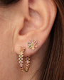 Model wearing medium marquise evil aye hoops with rainbow stones on each of the eyes, and a second earring with the same color stones to match.