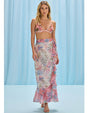 A vibrant tropical print skirt featuring a floral design, complementing a printed ruched bikini for a stylish beach look.