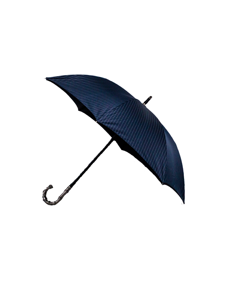 Dark navy/grey umbrella that is opened and tilted to the side in front of a white background.