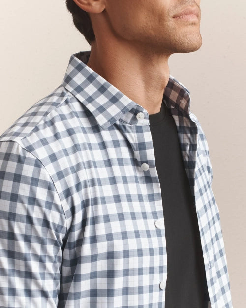 Close-up of a men's blue and white gingham check button-down shirt featuring a classic collar, button-front closure, and lightweight woven fabric.