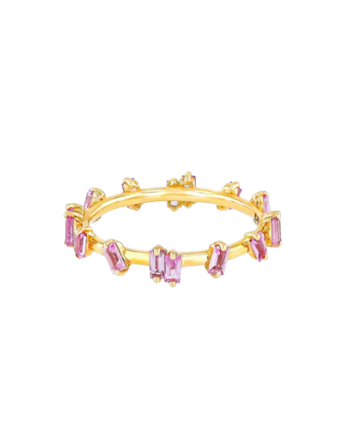 Gold band ring with pink sapphires cut to looked like barbed wire in front of white background. 