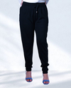 Model wearing black pants with adjustable waitband and pockets with white tee and blue heels.