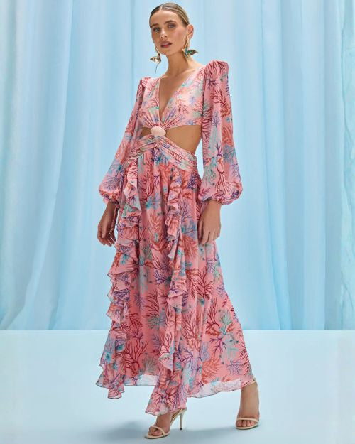 The model is dressed in a long-sleeved pink seaweed print beach dress, highlighting a stylish and feminine look.