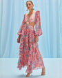 The model is dressed in a long-sleeved pink seaweed print beach dress, highlighting a stylish and feminine look.