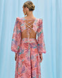 Back view of a woman wearing a pink seaweed beach dress, embodying a light and summery aesthetic.