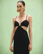 The PATBO Frida Mesh Midi Dress is worn by a woman, highlighting its elegant black fabric and unique cutout details