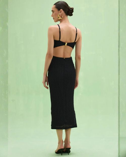 Woman's back view in a black PATBO Frida Mesh Midi Dress, highlighting the dress's stylish mesh details and fit.