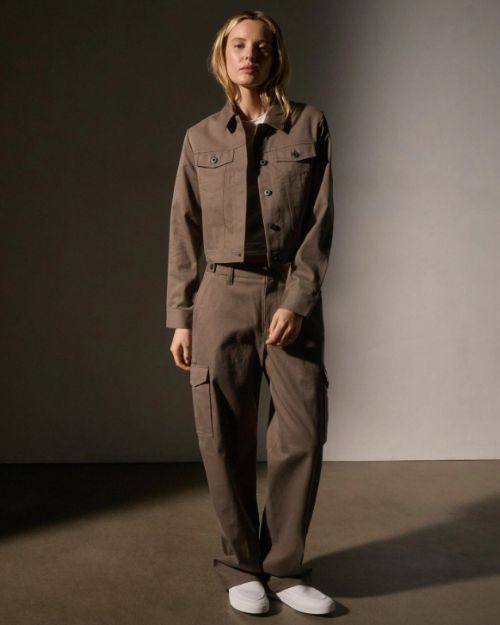 The model showcases a fashionable cashmere jacket paired with coordinating pants, exuding a chic look.